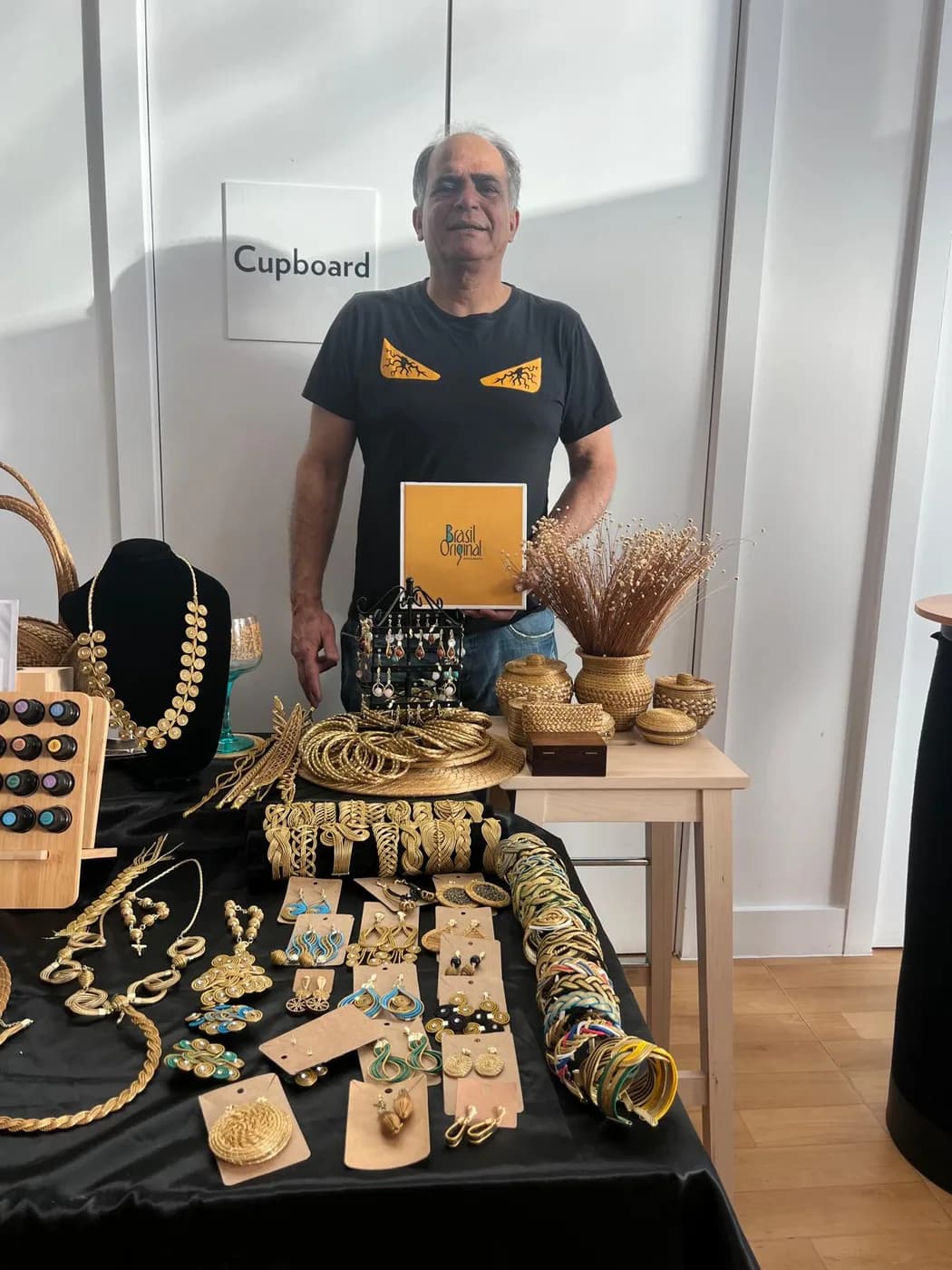 Samuel Moikato apresentando artesanato brasileiro em uma feira em Wembley