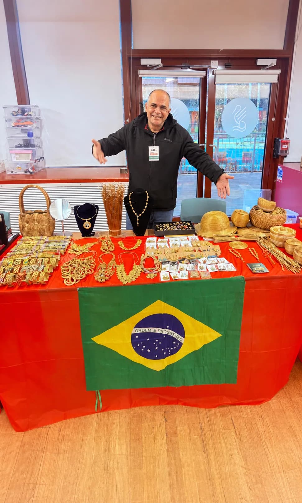 Samuel Moikato diante de uma banca com joias e peças artesanais